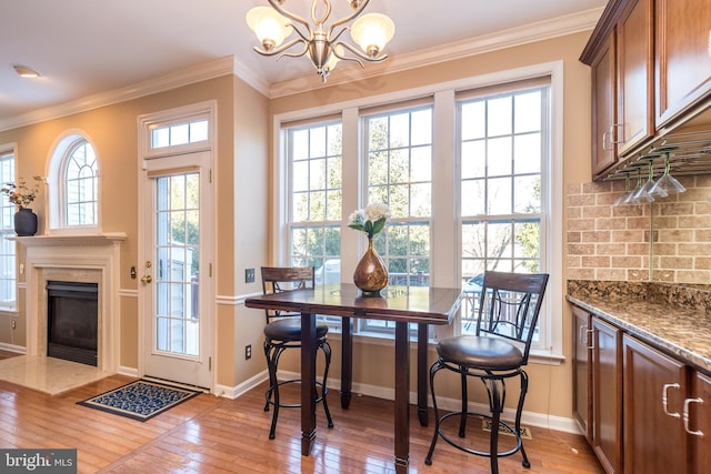 dining room featuring a wealth of natural light, light hardwood / wood-style flooring, and ornamental molding