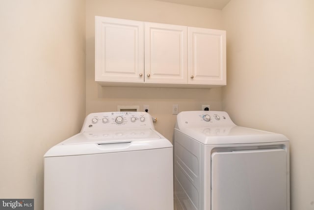 washroom featuring cabinets and washing machine and dryer