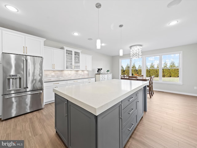 kitchen with white cabinets, high end fridge, a center island, gray cabinets, and backsplash