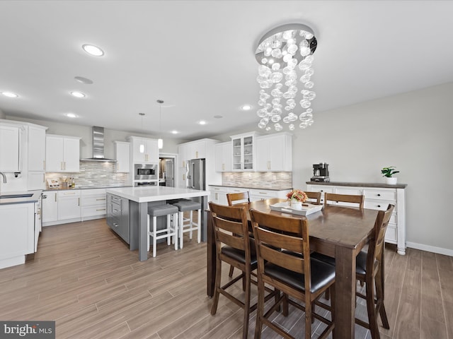 dining room with light wood-type flooring, baseboards, a chandelier, and recessed lighting