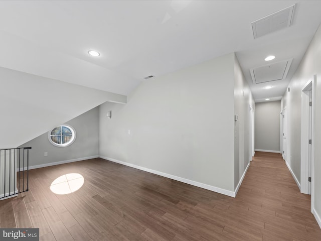 additional living space with lofted ceiling, visible vents, baseboards, and wood finished floors