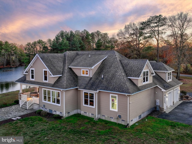 exterior space with driveway, roof with shingles, crawl space, and a lawn