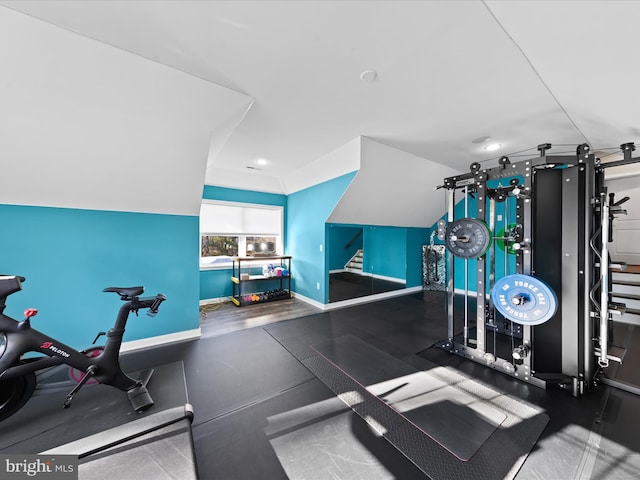 workout area with vaulted ceiling and baseboards