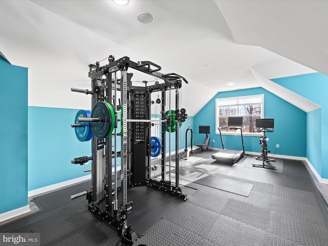 workout room with vaulted ceiling and baseboards