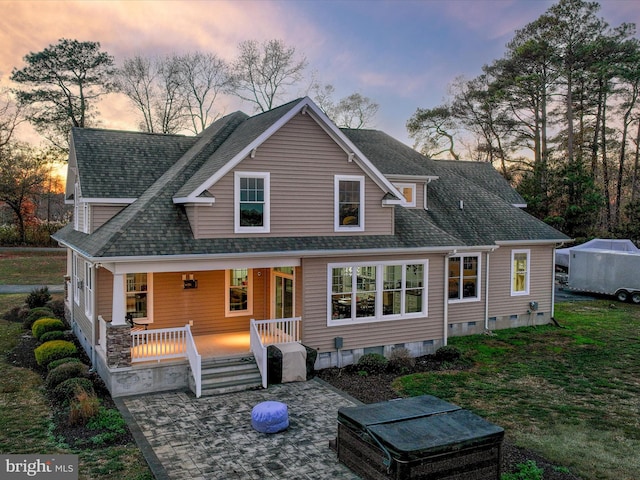 rear view of house featuring covered porch, a shingled roof, and crawl space