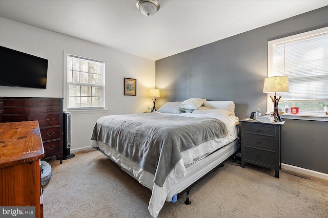 bedroom featuring light colored carpet and multiple windows