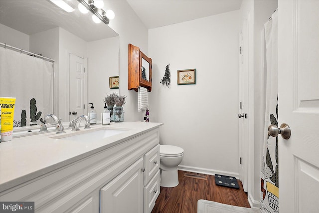 bathroom featuring vanity, hardwood / wood-style flooring, and toilet