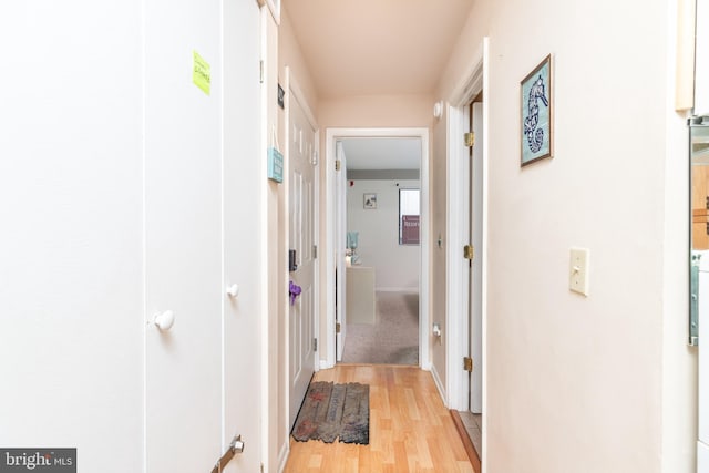 hallway with light hardwood / wood-style floors