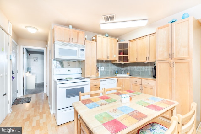 kitchen with white appliances, light brown cabinetry, and tasteful backsplash