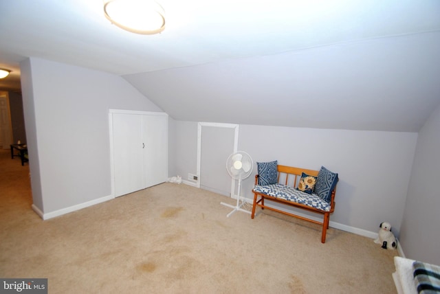 living area featuring lofted ceiling and light carpet