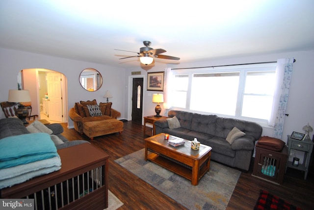 living room with ceiling fan and dark wood-type flooring