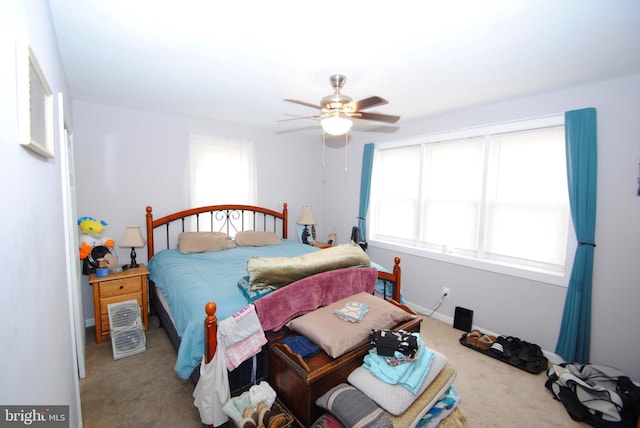 carpeted bedroom with multiple windows and ceiling fan