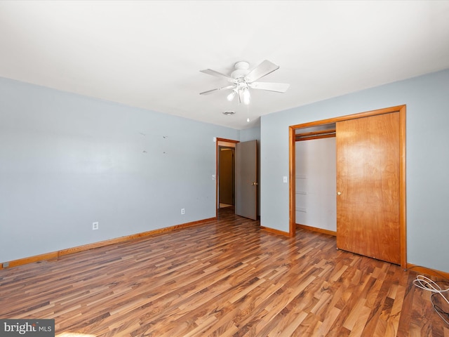 unfurnished bedroom with ceiling fan, a closet, and wood-type flooring