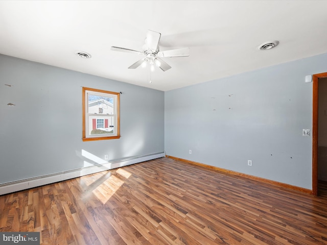 spare room with hardwood / wood-style flooring, a baseboard heating unit, and ceiling fan