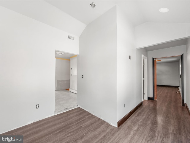 corridor featuring high vaulted ceiling and dark wood-type flooring