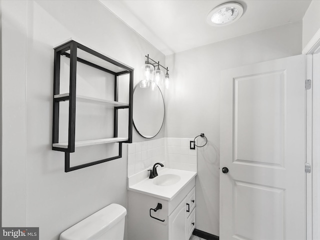 bathroom featuring tasteful backsplash, vanity, and toilet