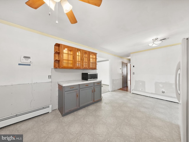 kitchen with ornamental molding, fridge, a baseboard radiator, and gray cabinets