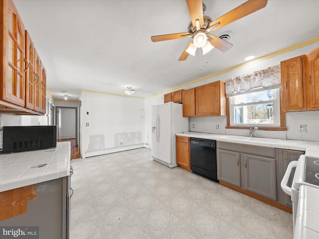 kitchen with tile counters, black appliances, baseboard heating, ceiling fan, and sink