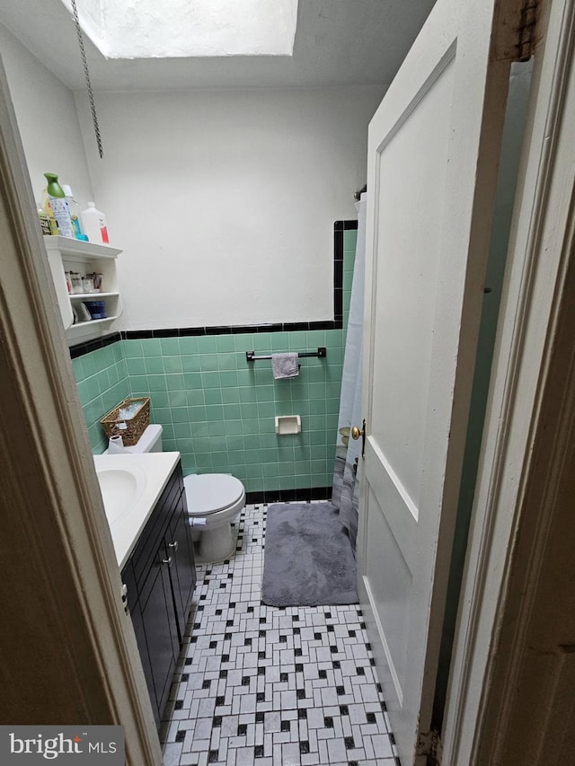 bathroom with walk in shower, vanity, and toilet