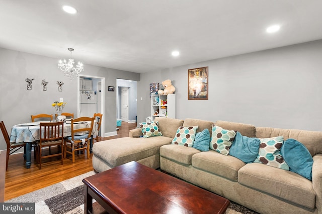 living room featuring an inviting chandelier and hardwood / wood-style floors