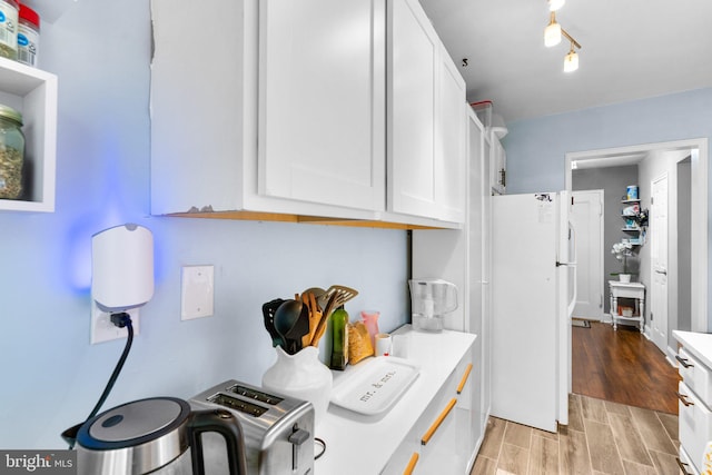 kitchen with white cabinetry and white refrigerator