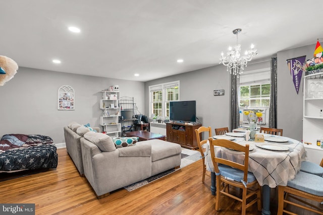 living room featuring a healthy amount of sunlight, radiator, and light hardwood / wood-style flooring