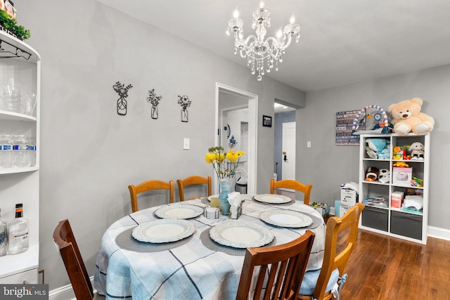 dining room with dark wood-type flooring and a chandelier