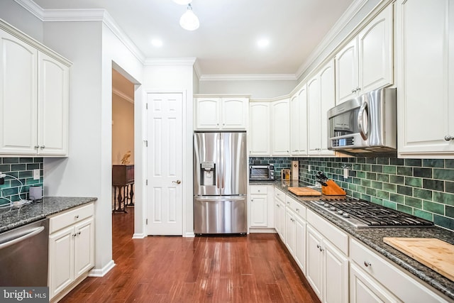 kitchen featuring dark stone counters, appliances with stainless steel finishes, and white cabinetry