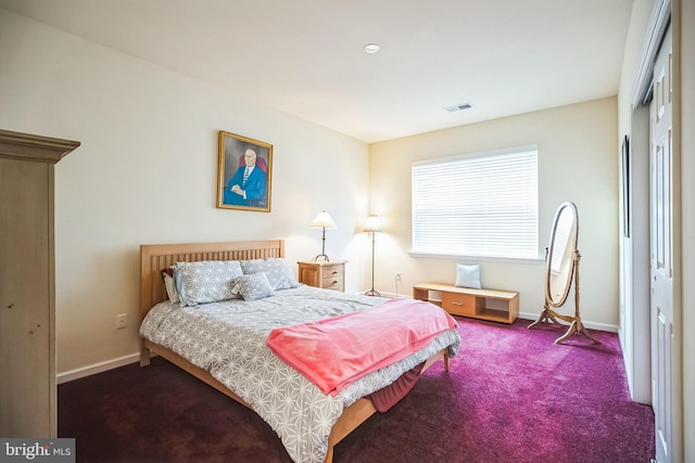 bedroom with a closet and dark colored carpet