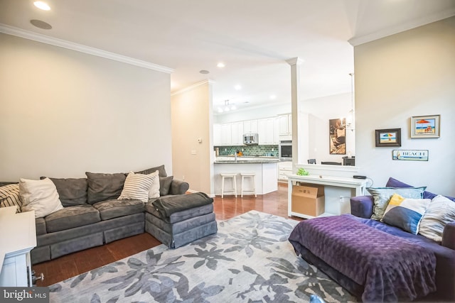 living room featuring sink, crown molding, and hardwood / wood-style flooring