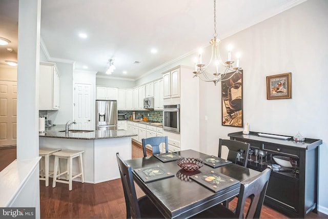 dining space with sink, dark wood-type flooring, ornamental molding, and a chandelier