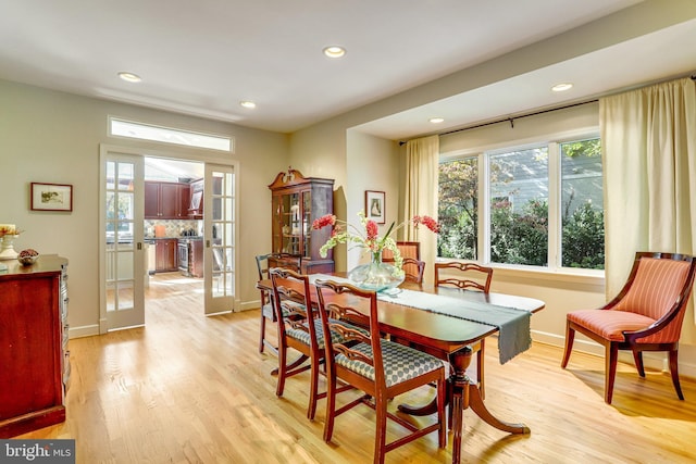 dining room with light hardwood / wood-style floors and french doors