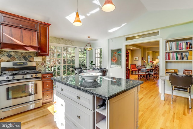 kitchen with gas range, white cabinetry, a kitchen island, and hanging light fixtures