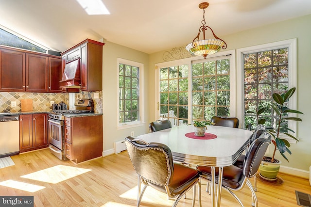 dining area featuring a baseboard radiator and light hardwood / wood-style floors