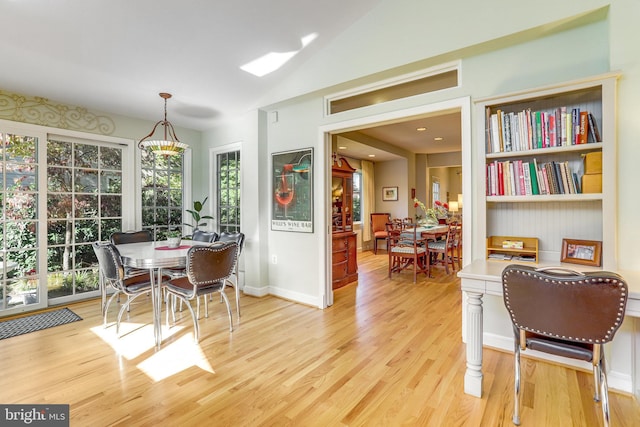 dining room featuring light hardwood / wood-style flooring and vaulted ceiling