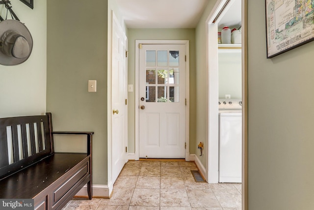 doorway with washer / clothes dryer and light tile patterned floors