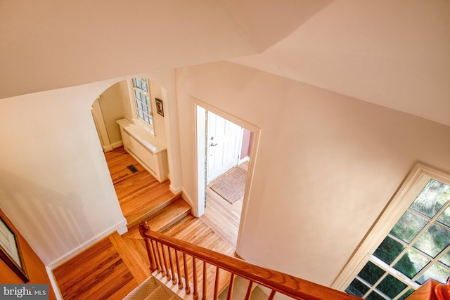 stairs with hardwood / wood-style flooring and lofted ceiling