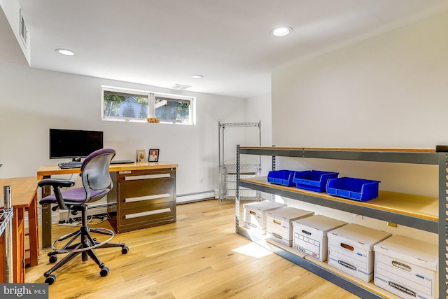 home office featuring a baseboard heating unit and light wood-type flooring