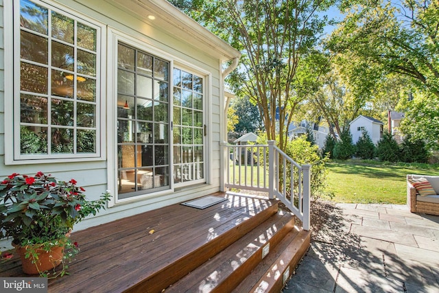 wooden terrace featuring a yard and a patio area