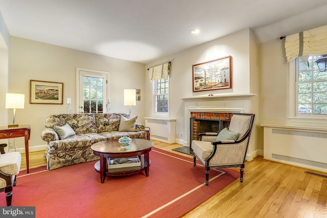 living room featuring plenty of natural light, radiator, and light hardwood / wood-style flooring