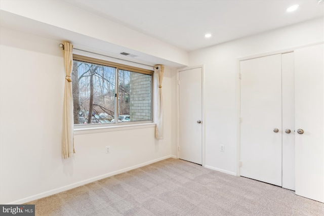 unfurnished bedroom featuring a closet and light carpet