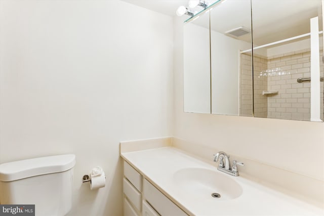 bathroom featuring vanity, toilet, and tiled shower