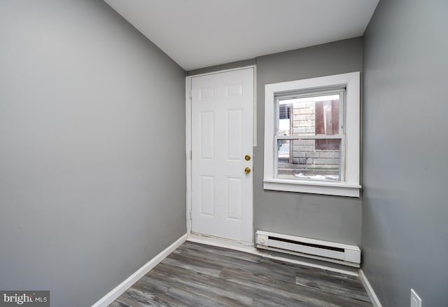 entryway with dark wood-type flooring and a baseboard heating unit