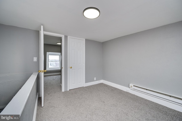 carpeted spare room featuring a baseboard radiator