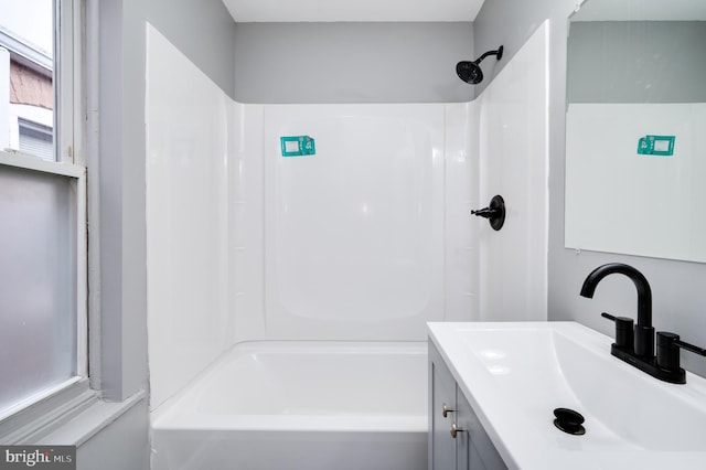 bathroom with vanity, a healthy amount of sunlight, and tub / shower combination