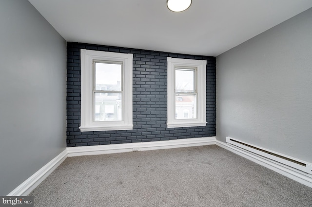 spare room with carpet floors and a baseboard heating unit