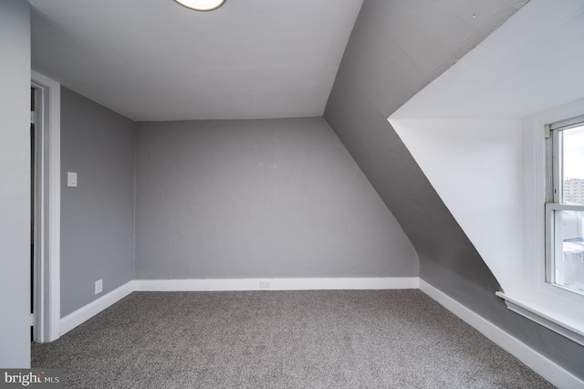 additional living space with carpet flooring and vaulted ceiling