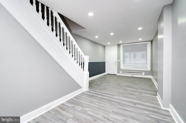 foyer featuring baseboard heating and light hardwood / wood-style floors