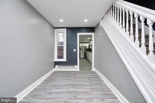 staircase with a baseboard radiator and hardwood / wood-style flooring