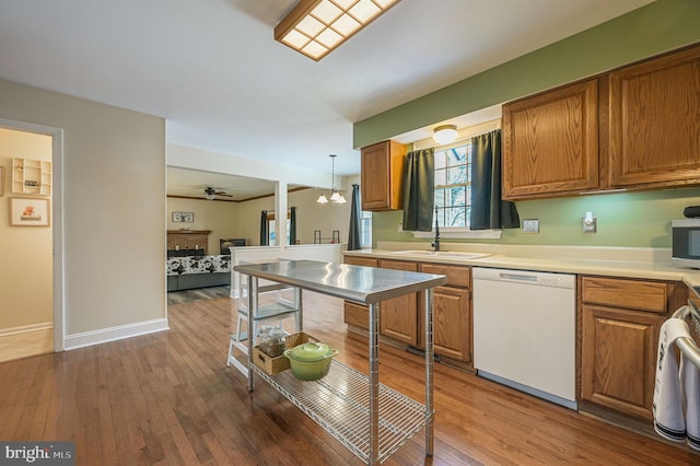 kitchen with ceiling fan with notable chandelier, dishwasher, sink, hanging light fixtures, and hardwood / wood-style flooring